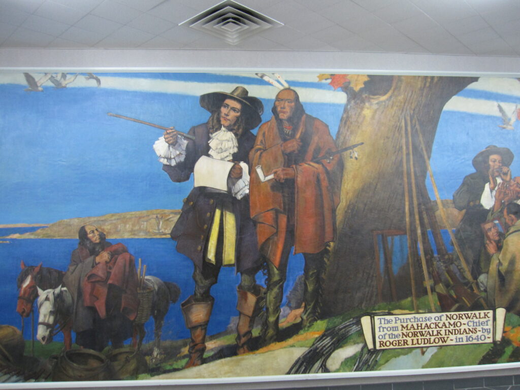 A historical mural depicts a scene where a colonial settler talks with a Native American chief under a large tree. Two horses and more people are in the background. A sign reads, The Purchase of Norwalk by Roger Ludlow, 1640.